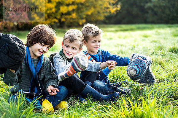Drei Jungen sitzen zusammen auf dem Feld  im Herbst