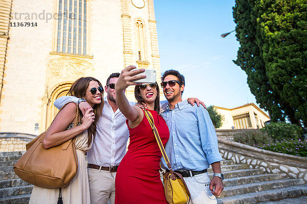 Zwei Touristenpaare beim Selfie vor der Kirche  Calvia  Mallorca  Spanien