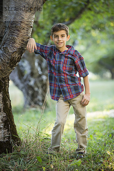 Lächelnder Junge an einem Kirschbaum