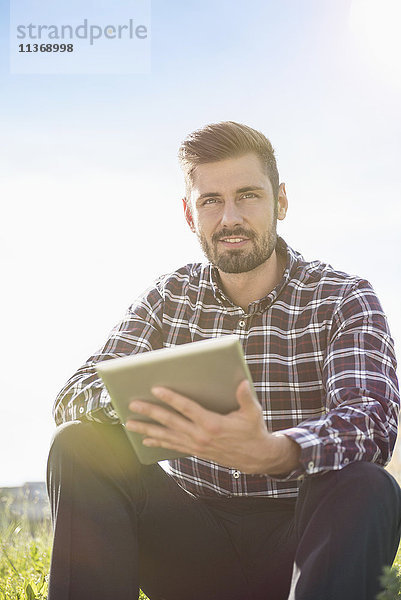 Junger Mann mit digitalem Tablet