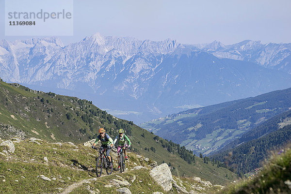 Zwei befreundete Mountainbiker beim Bergauffahren  Zillertal  Tirol  Österreich