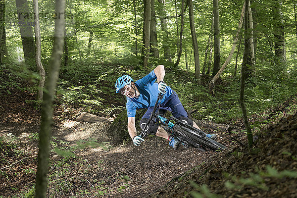 Mountainbiker fährt bergab im Wald