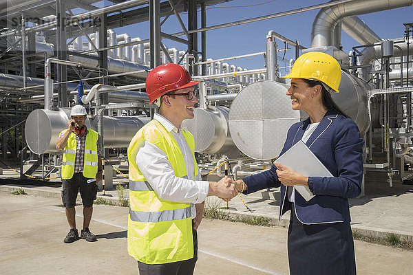 Geschäftsmann und Ingenieur beim Händeschütteln im Geothermiekraftwerk