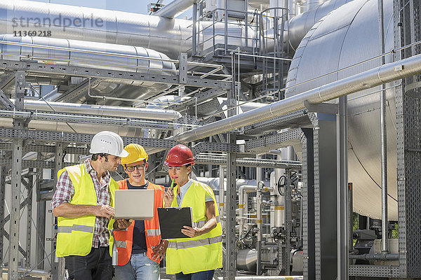 Ingenieur mit seinen Kollegen bei einer Besprechung mit Laptop im geothermischen Kraftwerk