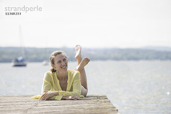 Nachdenkliche Frau  die sich auf der Uferpromenade am See ausruht  Ammersee  Oberbayern  Deutschland