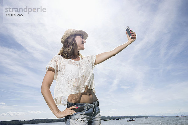 Frau macht Selfie am See  Ammersee  Oberbayern  Deutschland