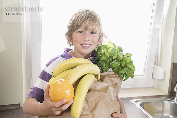 Porträt eines glücklichen Jungen mit Einkaufstasche