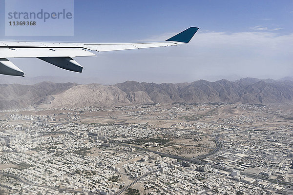 Beschnittenes Bild eines Flugzeugs  das über die Stadt fliegt  Maskat  Oman