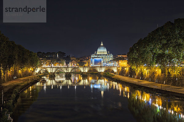Beleuchteter Petersdom an der Brücke über den Fluss bei Nacht  Rom  Italien