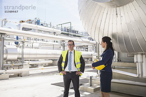 Zwei Ingenieure warten auf dem Gelände eines geothermischen Kraftwerks