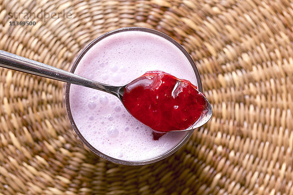 Nahaufnahme von Erdbeermarmelade mit Joghurtbecher auf Korb