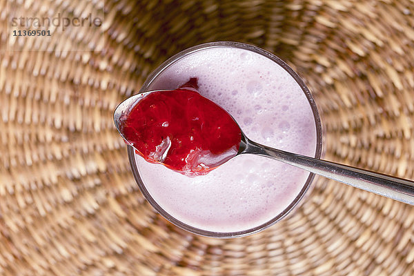 Nahaufnahme von Erdbeermarmelade mit Joghurtbecher auf Korb