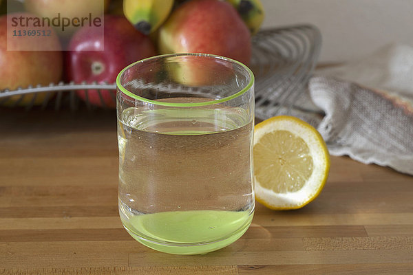 Nahaufnahme von Zitronenwasser mit Früchten im Hintergrund