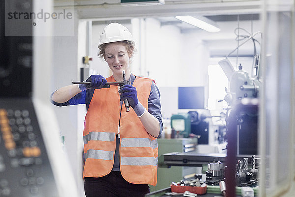 Junge Ingenieurin bei der Reparatur eines Maschinenteils in einer Industrieanlage