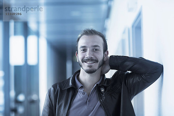 Porträt eines jungen männlichen Ingenieurs im Technikraum und lächelnd