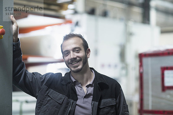 Porträt eines jungen männlichen Ingenieurs im Technikraum und lächelnd