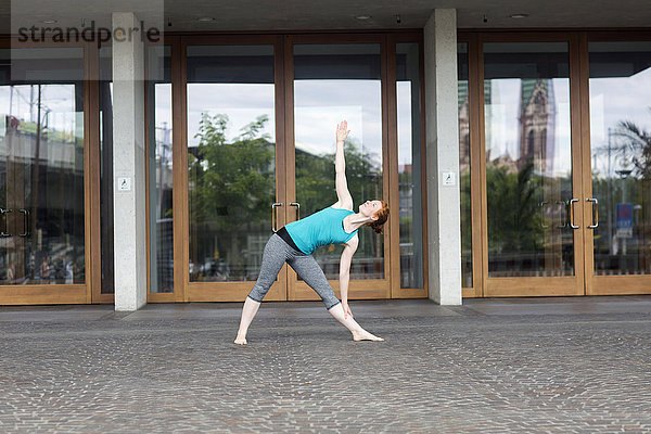 Junge Frau beim Yoga in einer Großstadt