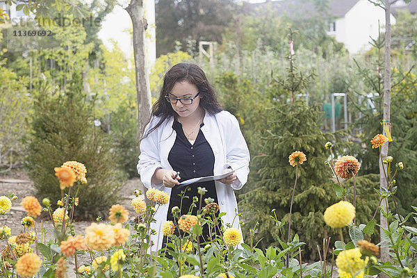 Wissenschaftlerin inspiziert Blumen im Gewächshaus  Freiburg im Breisgau  Freiburg im Breisgau  Deutschland