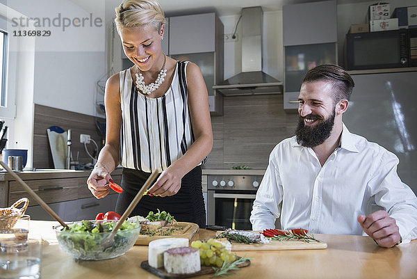 Ehepaar bei der Zubereitung von Speisen in der Küche