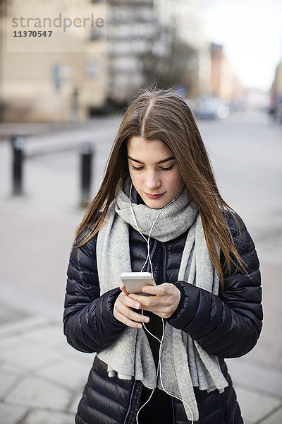 Teenager-Mädchen benutzt Mobiltelefon