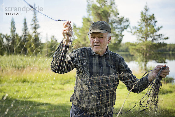 Älterer Mann mit Fischernetz