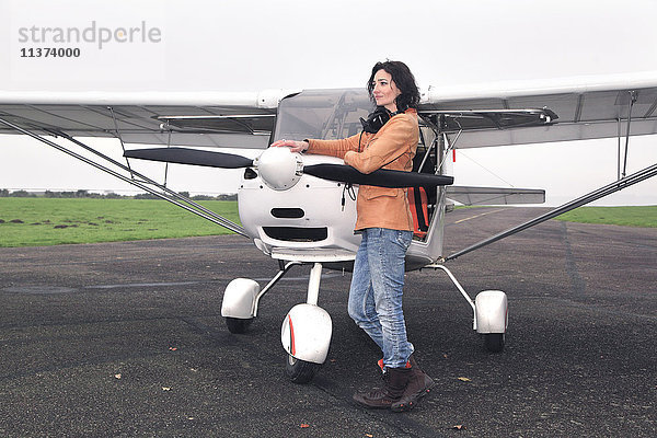 Pilotin vor ihrem Ultraleichtflugzeug auf der Startbahn.