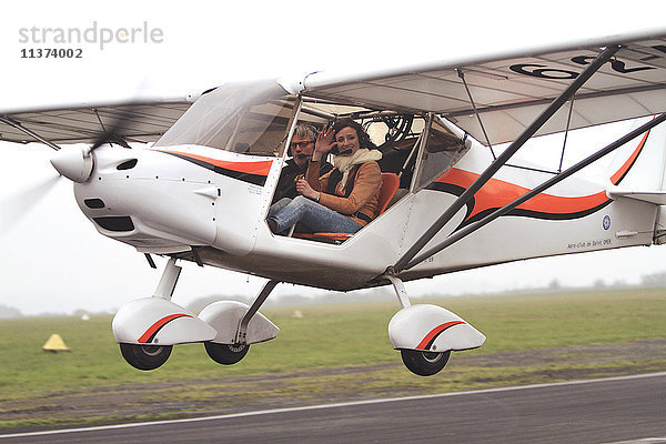Pilotin  junge Frau  die ein Ultraleichtflugzeug fliegt.