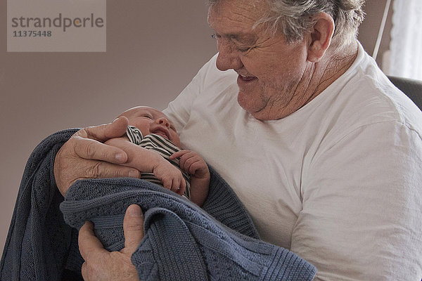 Kaukasischer Großvater hält Baby-Enkel