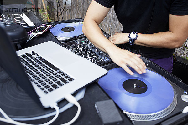 Hispanischer DJ spielt Musik im Hinterhof