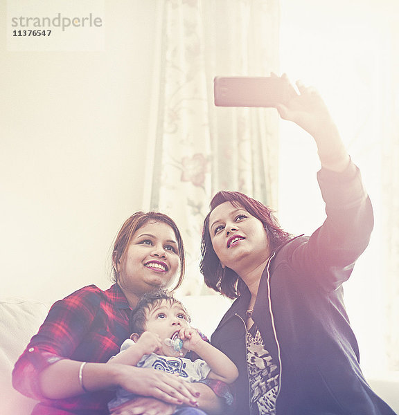 Indische Frauen posieren für ein Handy-Selfie mit einem kleinen Jungen