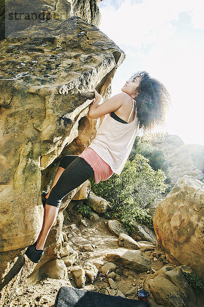 Hispanische Frau beim Klettern