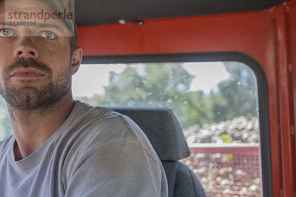 Porträt eines ernsten kaukasischen Mannes in einem Traktor