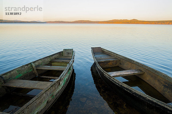 Zwei Ruderboote auf dem See bei Sonnenuntergang