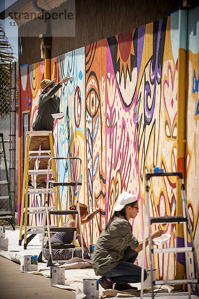 Menschen malen Wandmalerei an der Wand
