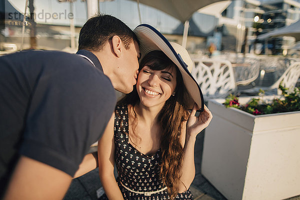 Kaukasischer Mann küsst Frau auf die Wange
