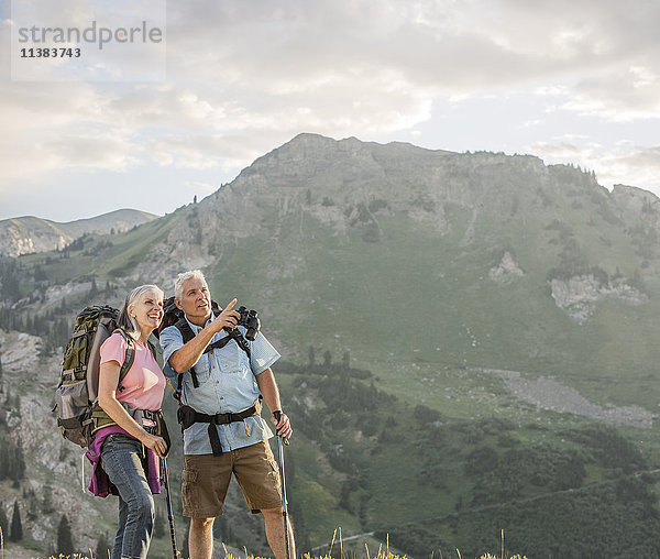 Kaukasisches Paar mit Fernglas beim Wandern auf einem Berg