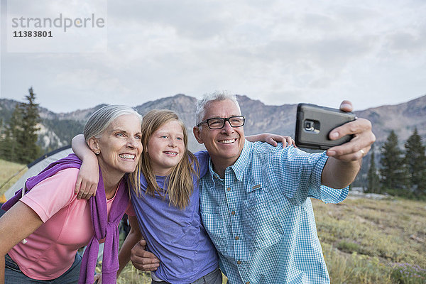 Kaukasische Großeltern und Enkelin posieren für ein Handy-Selfie