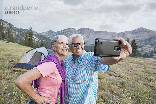 Kaukasisches Paar posiert für Handy-Selfie auf Berg