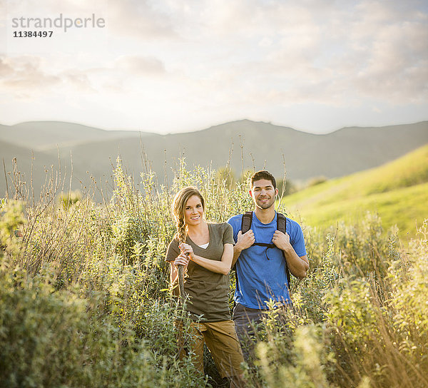 Porträt eines kaukasischen Paares beim Wandern auf einem Hügel