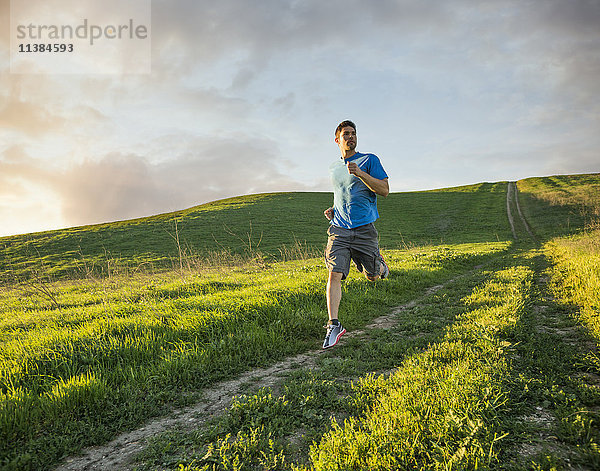 Hispanischer Mann läuft auf einem Hügel