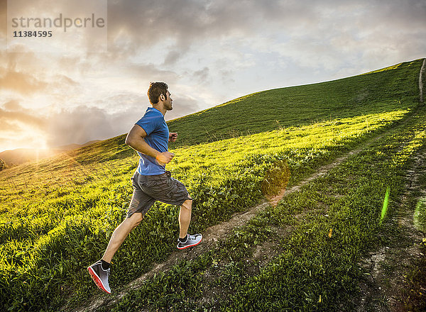 Hispanischer Mann läuft auf einem Hügel