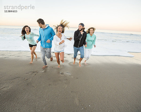 Lächelnde Freunde laufen am Strand