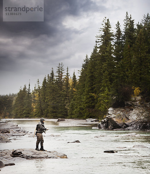 Kaukasischer Mann beim Fischen am Fluss