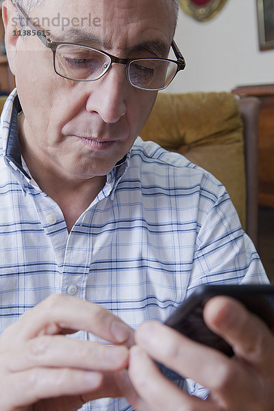 Hispanischer Mann schreibt eine SMS auf seinem Handy