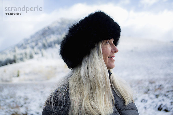 Kaukasische Frau mit Pelzmütze im Winter