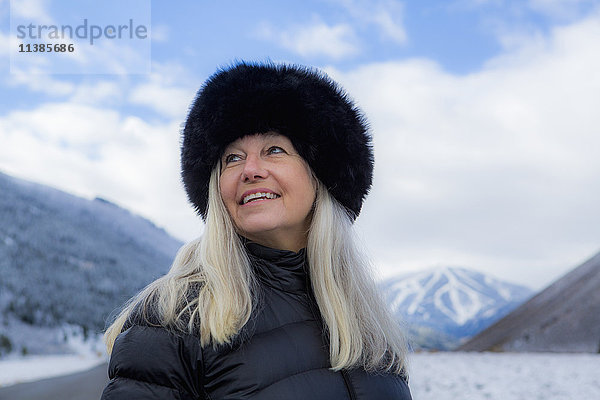 Kaukasische Frau mit Pelzmütze im Winter