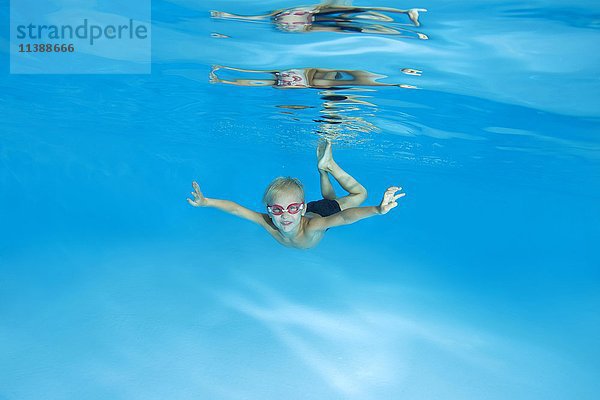 Kleiner Junge mit Schwimmbrille  der im Schwimmbad das Unterwasserschwimmen lernt  Ukraine  Europa