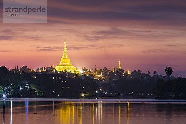 Beleuchtete Shwedagon-Pagode bei Sonnenuntergang  gesehen vom Kandawgyi-See  Yangon  Myanmar  Asien