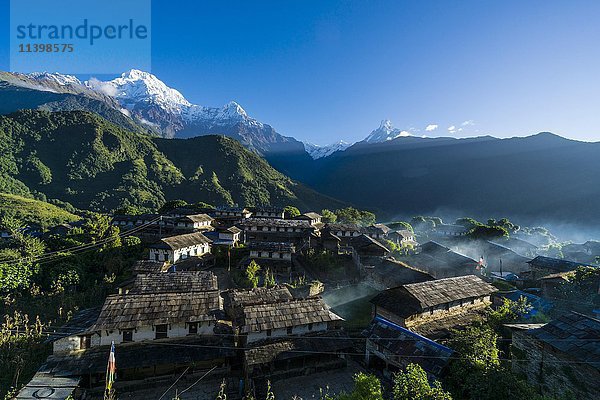 Blick auf das Dorf  im Hintergrund die Berge Annapurna Süd  links  Himchuli  Mitte  und Machapuchare  rechts  Ghandruk  Kaski District  Nepal  Asien