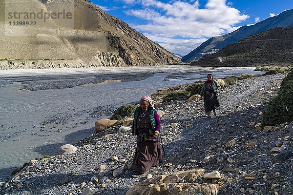 Zwei einheimische Frauen  die am Fluss spazieren gehen  in der Nähe von Jomsom  Kali-Gandaki-Tal  Bezirk Mustang  Nepal  Asien